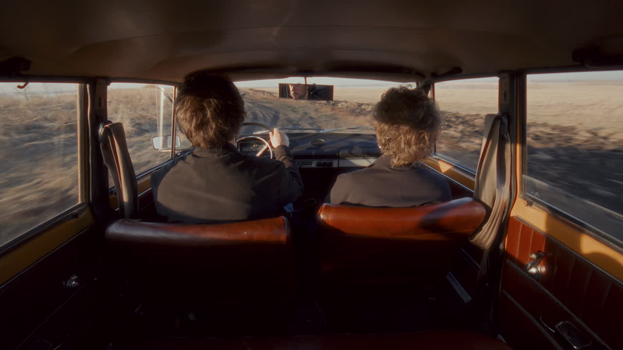 Couple Traveling in Retro Car through Open Rural Landscape