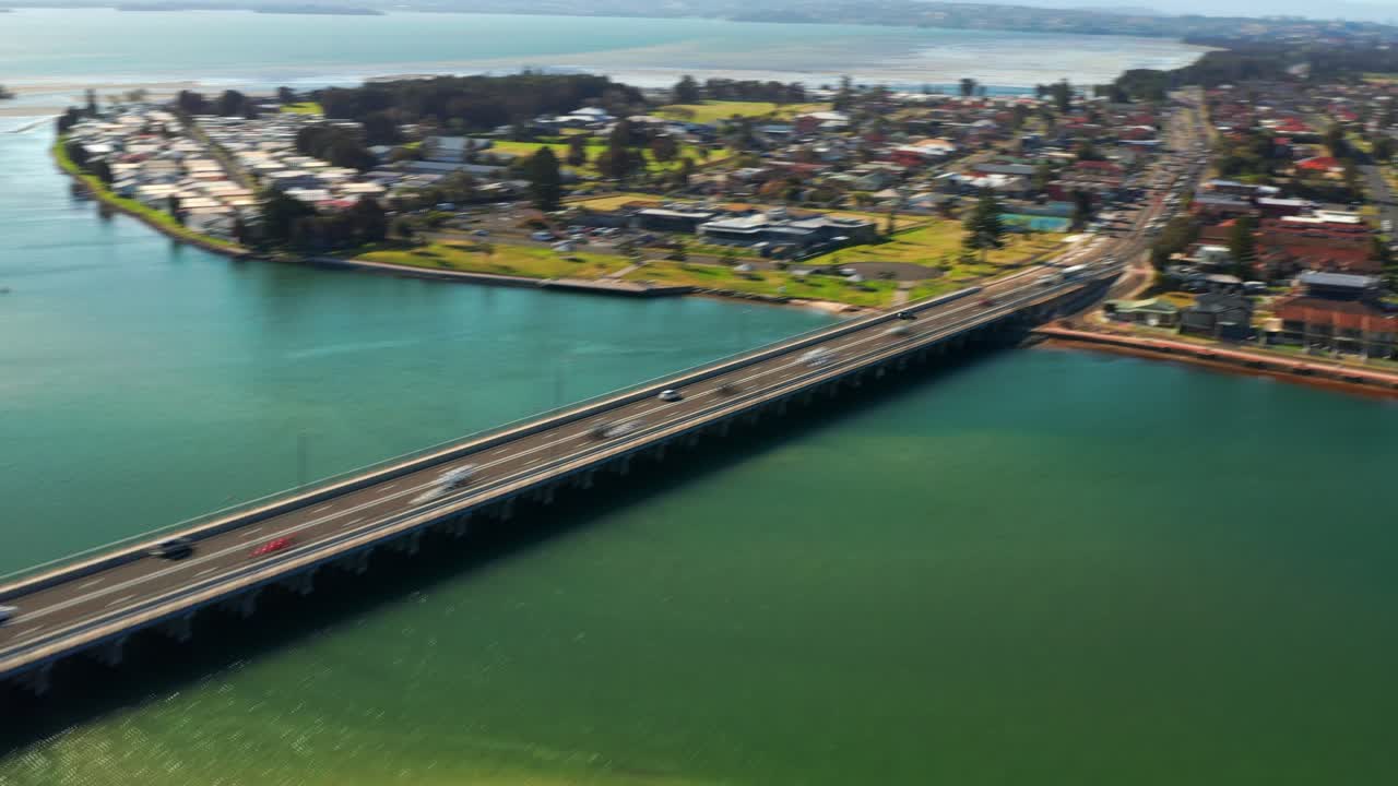 hiperlapso aéreo coches en movimiento rápido en el puente de la carretera de windang y el suburbio de windang en nsw, australia