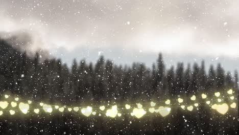 animation of falling snow glowing heart christmas string lights and winter landscape