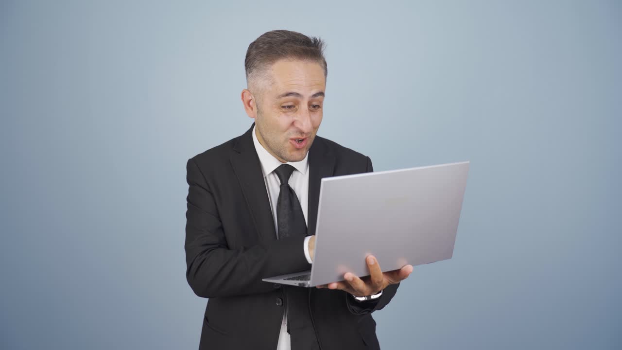 hombre de negocios mirando la computadora portátil con emoción.