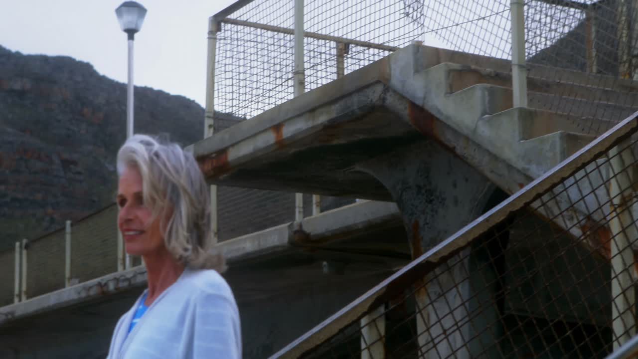 mujer mayor bajando los escalones en la playa