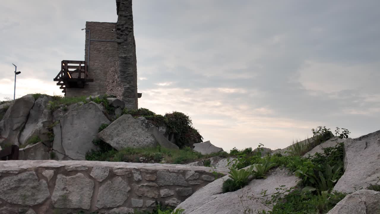 Scenic view inside the Fortress of Deva, featuring enormous boulders surrounded by weathered ruins atop the hill