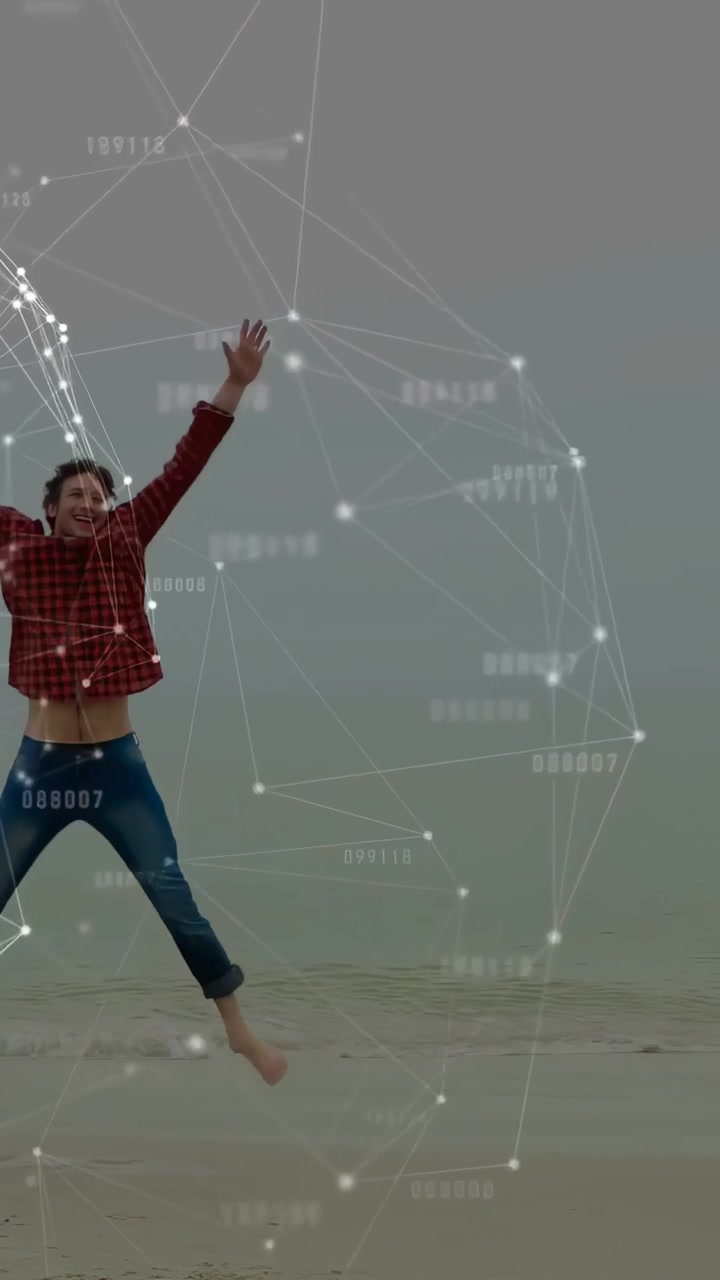 세로 영상: 모래에서 뛰어올라 해변을 따라 즐겁게 점프하는 남자, AR 오버레이 추적 노드가 적용된 모습