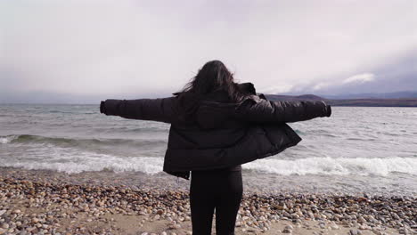 forward moving clip captures fearless female standing against the wind, with waves thrashing as sunlight breaks through clouds. ideal for liberation or self-discovery narratives