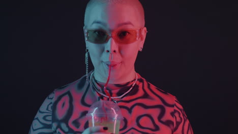 woman drinking neon-lit beverage