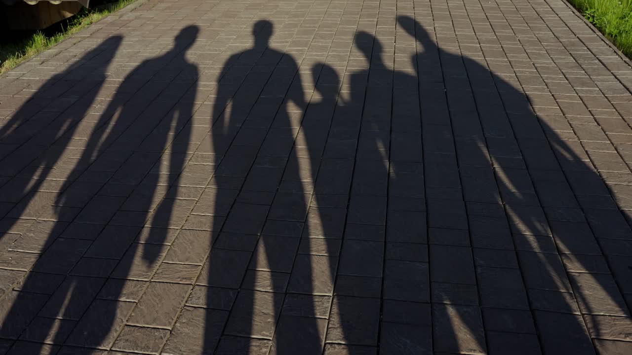 Shadows of a Family on a Paved Pathway