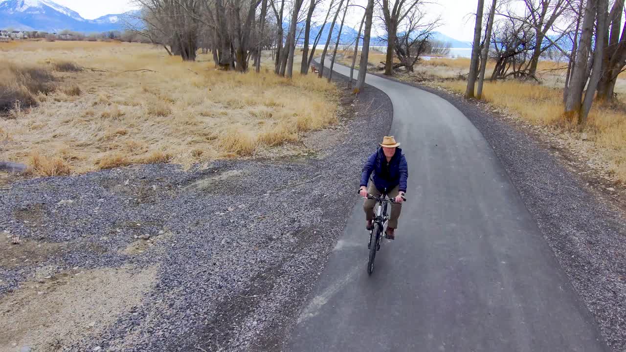 구불 구불 한 자연 산책로를 따라 배낭 자전거를 착용하는 수석 남성 자전거 타는 사람 - 공중보기
