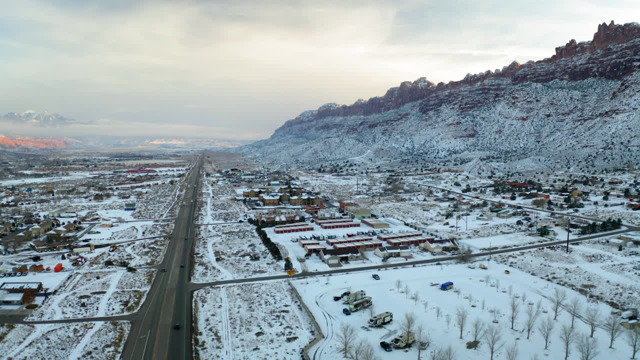 Aerial View of a Snow-Covered Town with Mountains in Winter