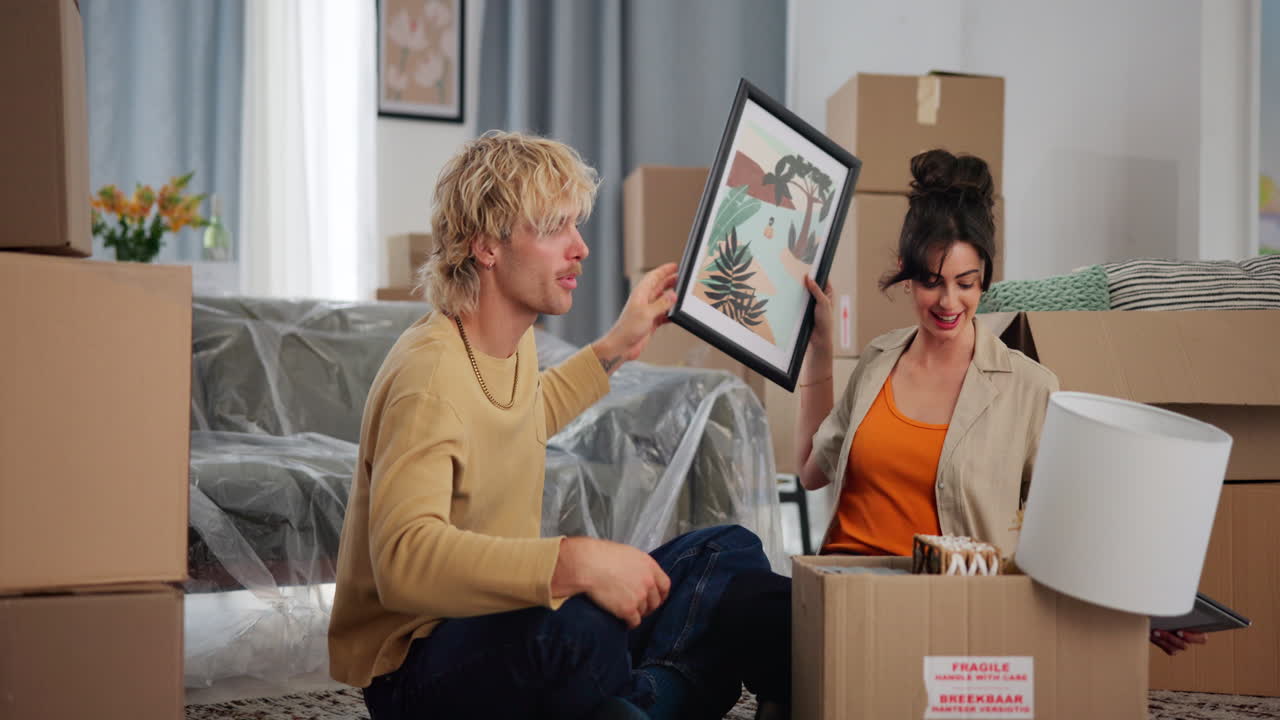 Happy Young Couple Unpacking Boxes in Their New Home