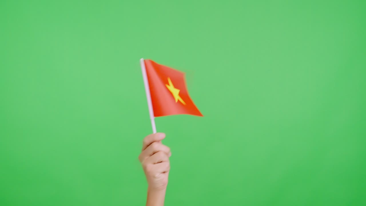 Hand waving a pennant of a vietnamese national flag