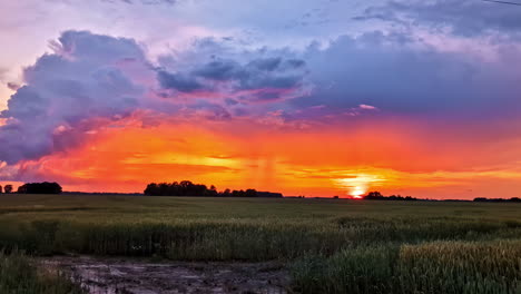 colorful storm clouds over field during dramatic sunset in rural countryside
