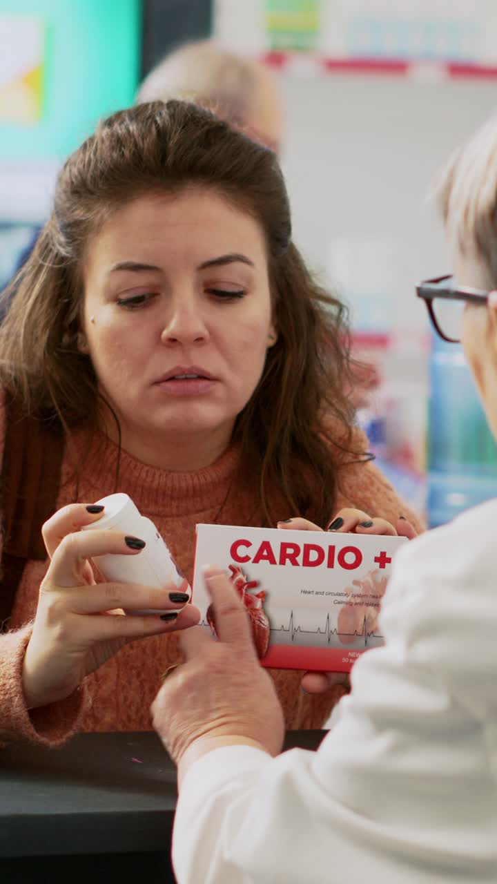 Video verticale: donna che mostra pillole di cardiologia a un farmacista