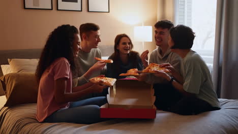 friends eating pizza in bedroom