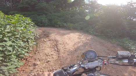 motociclista montando campo a través en un denso callejón verde montando a la montaña en la colina de parasnath en jharkhand, india