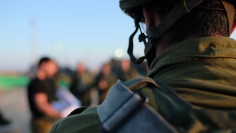 close-up of a combat soldier's neck when in the background his commander gives his team instructions