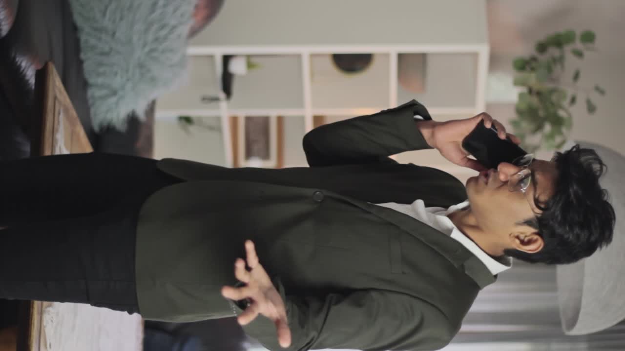 화가 나고 전화로 몸짓을 하는 양복을 입은 수직 전문 청년