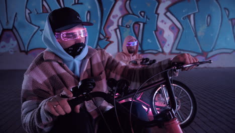 urban cyclists riding in neon lights surrounded by a vibrant graffiti background scene