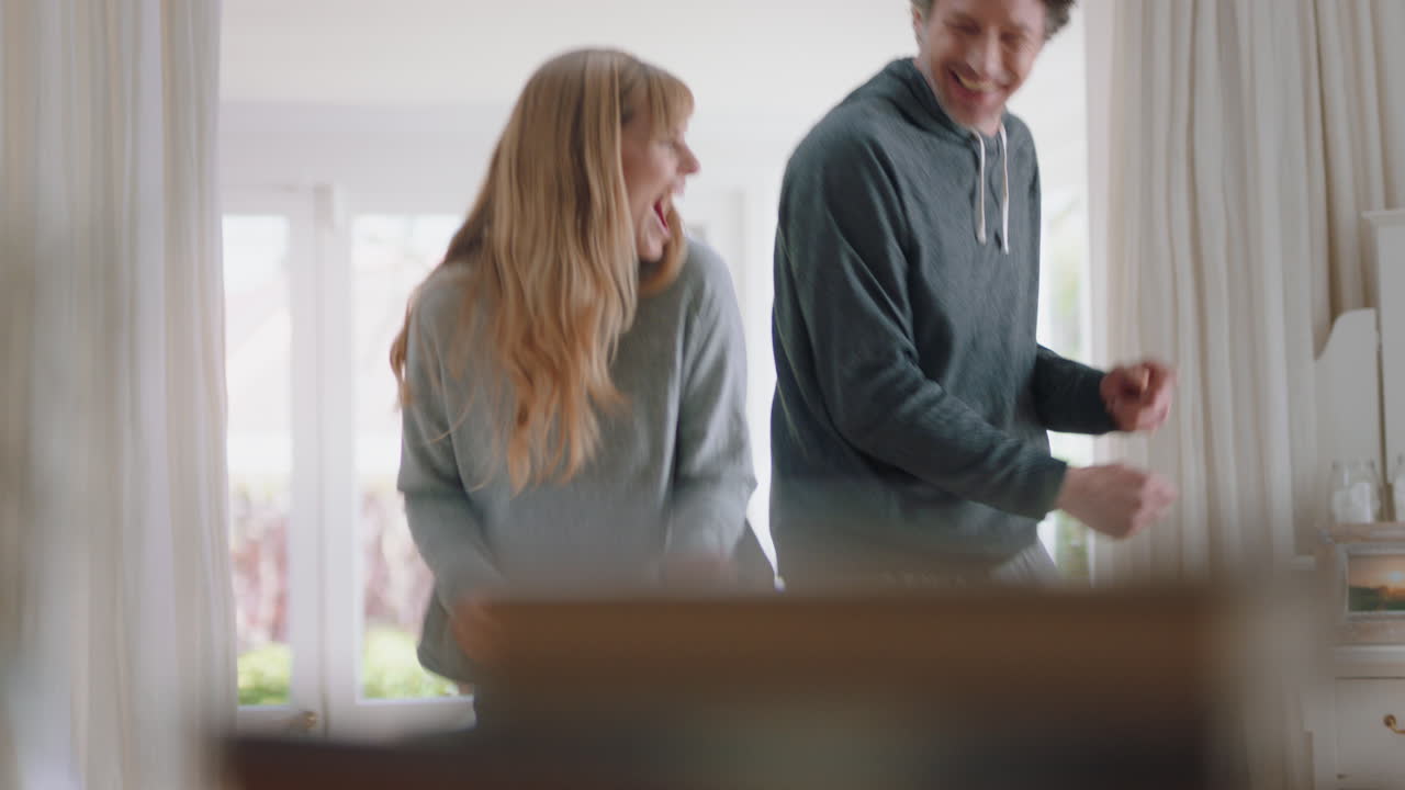 pareja joven feliz bailando en casa celebrando divirtiéndose fin de semana por la mañana juntos disfrutando de un divertido baile en el dormitorio celebración de una relación exitosa 4k footage