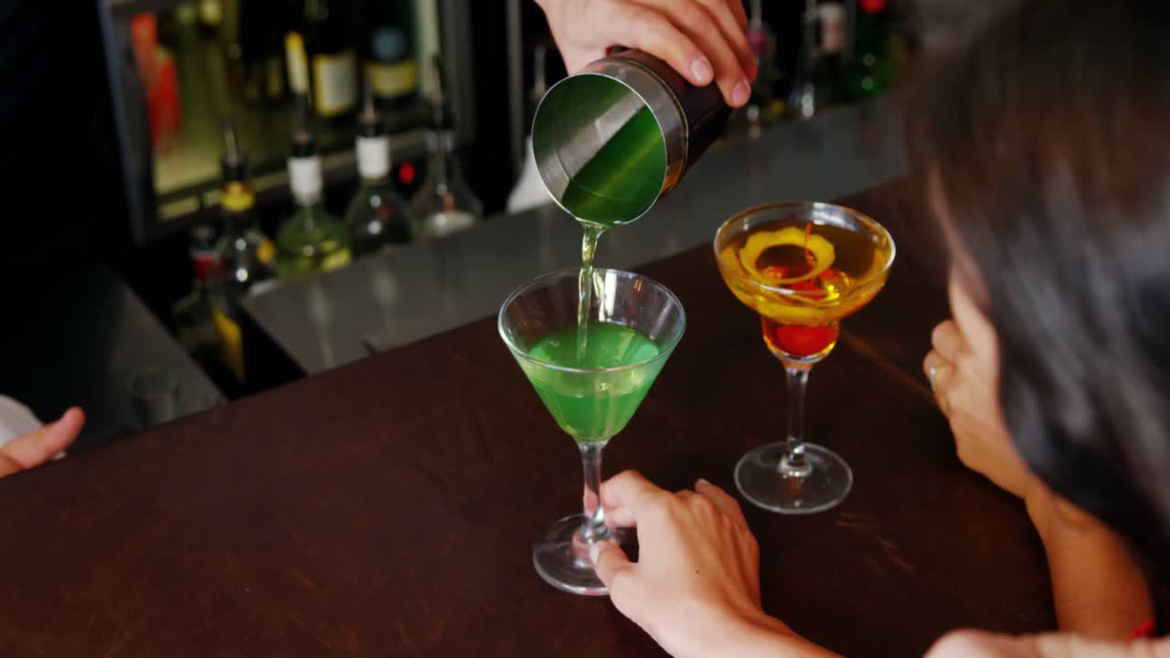 Primo piano di un barman che serve un cocktail a una donna