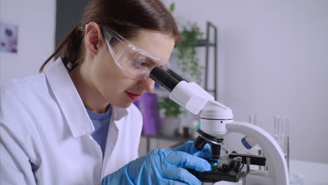 científica que utiliza el microscopio en un entorno de laboratorio