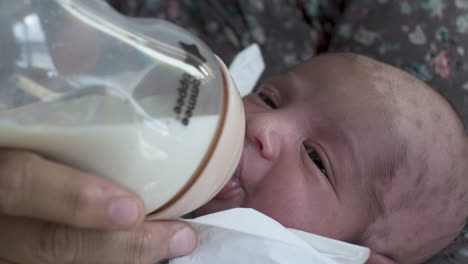 newborn baby boy drinking breast milk from bottle