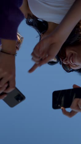 people holding phones from below with sky background