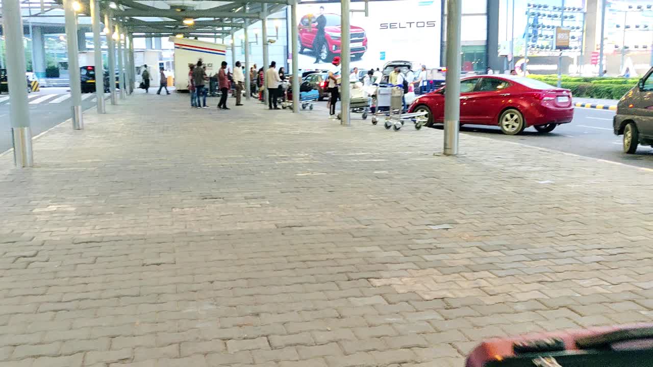 A man carrying luggage in a trolley at Delhi airport during departure. Outside the airport for travelling towards check-in