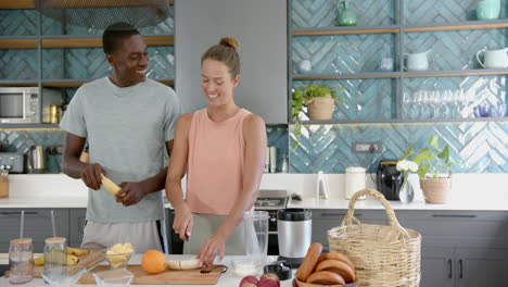 diverse couple preparing food together in kitchen, at home, copy space