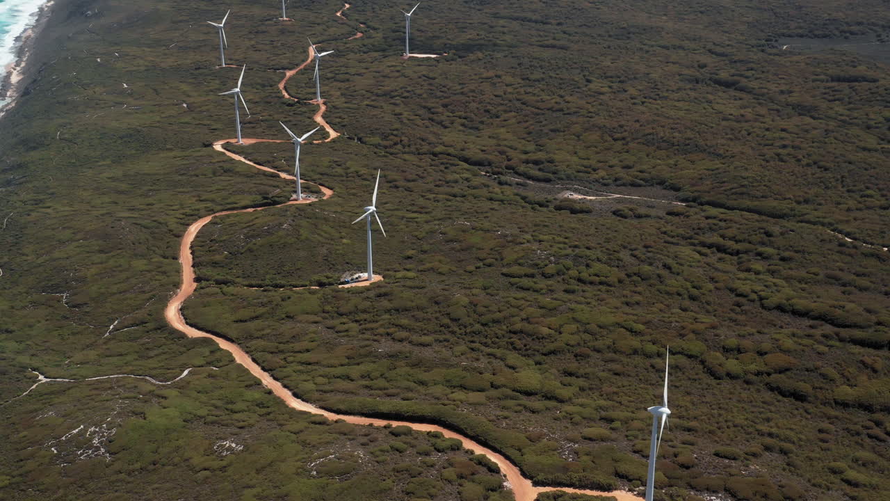 Aerial view overlooking wind power generators, on the coastline of Albany, sunny day, in Australia - reverse, Drone shot