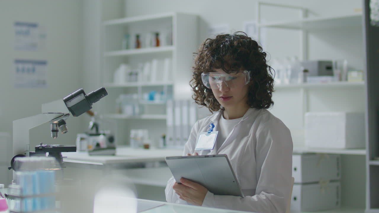 Young Female Scientist Using Digital Tablet in Modern Medical Laboratory