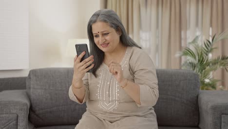 Happy-Indian-old-woman-scrolling-phone