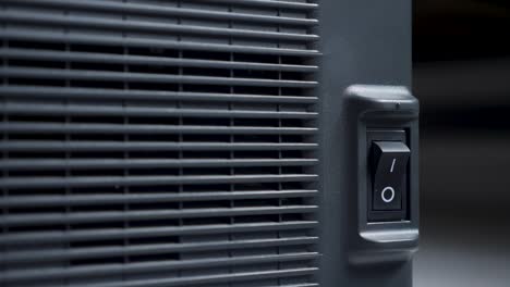 finger of a person presses turns on and off on a black plastic button