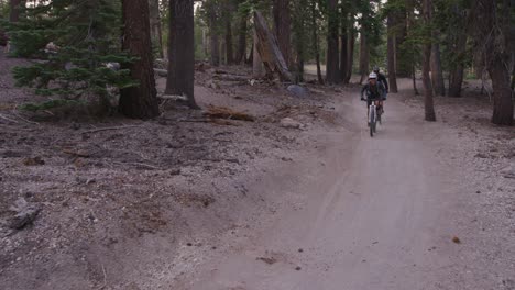 Two-montaña-bikers-ride-through-a-forest-2