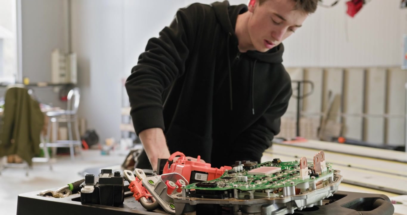 Technician working on the repair of an electric car battery module in a modern workshop focus on the