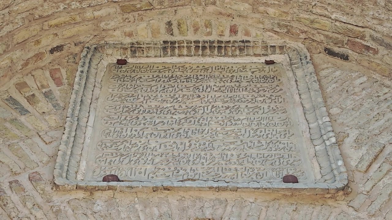 Ancient Stone Inscription with Arabic Calligraphy on Historic Brick Wall
