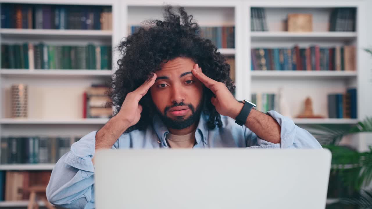 Troubled young arabian man learns about new problem sits at office table