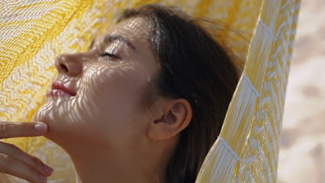 una chica romántica disfrutando de la luz del sol en una hamaca de primer plano.