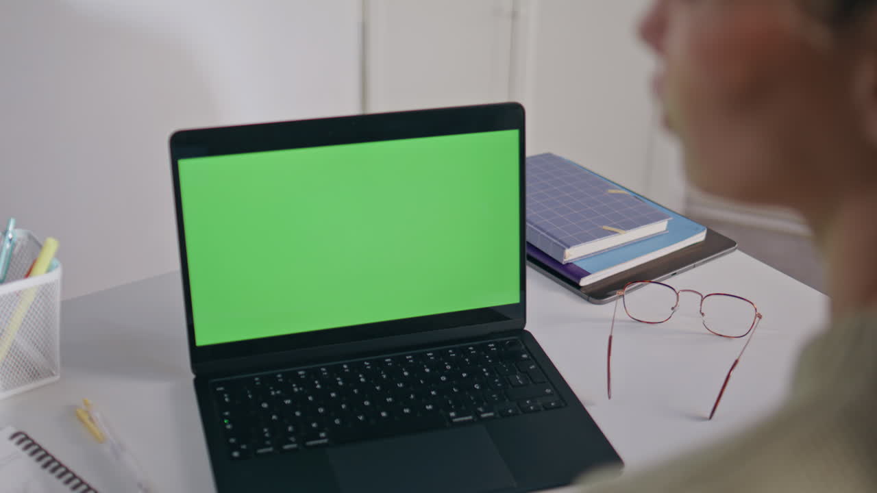 Woman looking greenscreen laptop in school office closeup. Tutor online lesson