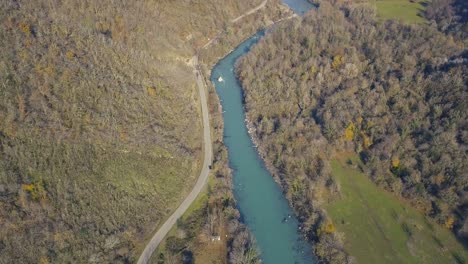 aerial view of a river winding through a valley with a road and forest