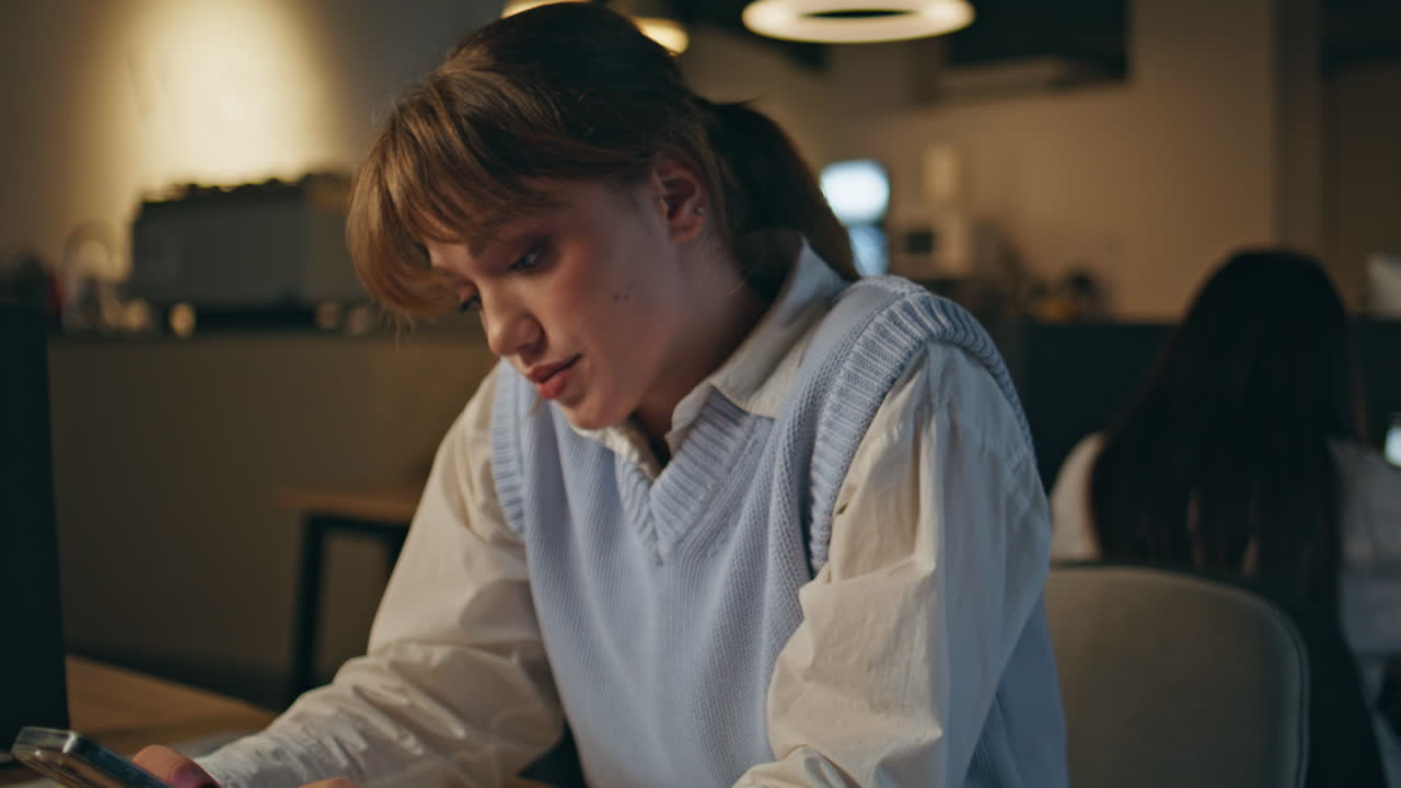 Late worker feeling upset thinking at dark office closeup. Woman waiting message