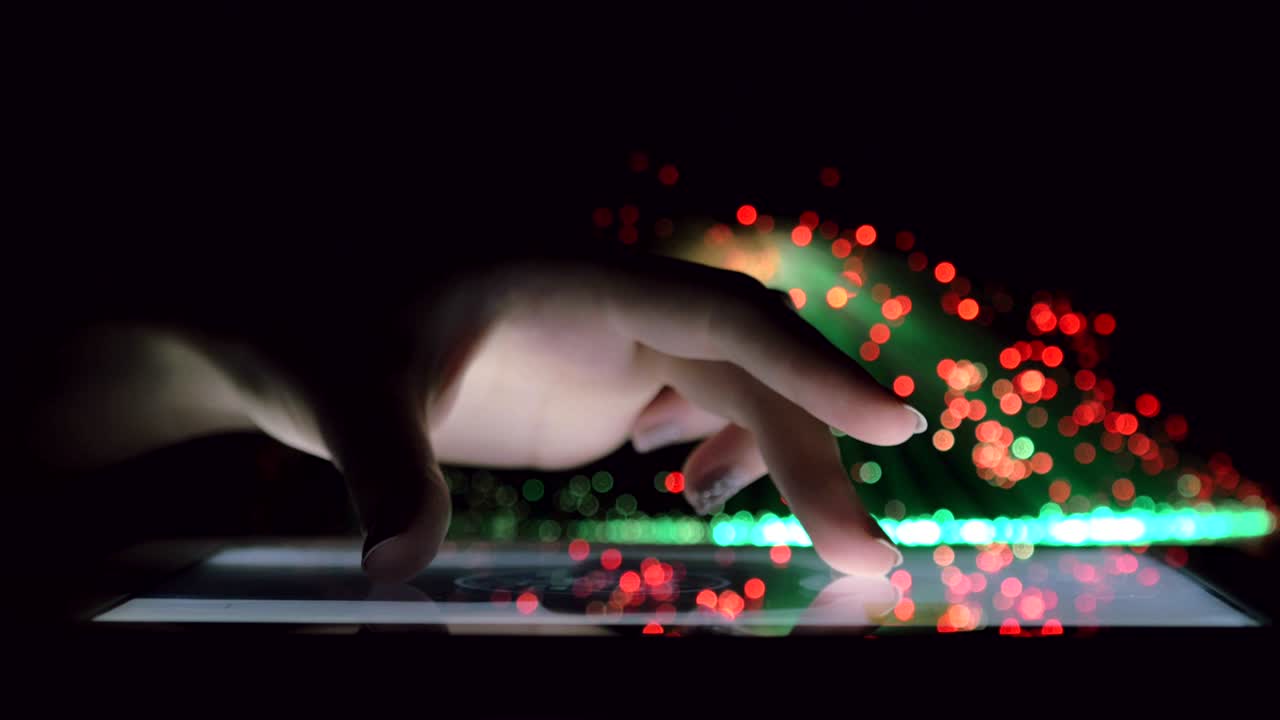 Woman Hand Touching And Browsing On Tablet Device In Dark Room With Colorful Blurry Fiber Optic Lights Closeup Vertical Tilt Motion