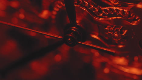 macro shot of seconds hand of a pocket watch ticking in red light as time pass by