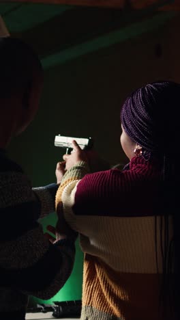vertical video firing range expert providing guide to woman on holding pistol