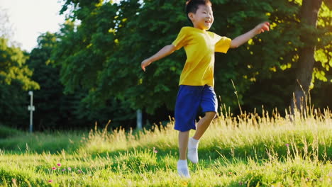 young asian boy happily running and playing in a sunny park