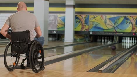 two young disabled men in wheelchairs playing bowling in the club