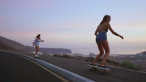 a slow-motion scene captures two friends skateboarding on a road at sunset, with mountains and a picturesque sky in the background. they're dressed in shorts