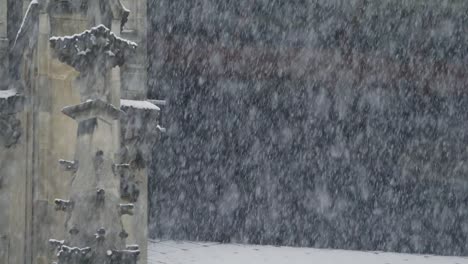 heavy snow falling before a blurred background of a minster