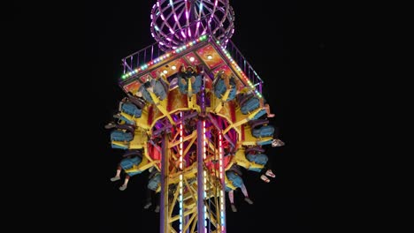 a full load of people on the mega drop fair rider, waiting for the ride to drop in anticipation