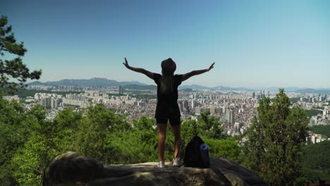 Sexy-Dame,-Die-Auf-Dem-Felsen-Steht,-Hebt-Ihre-Hände-In-Die-Luft-Am-Gwanaksan-berg-In-Seoul,-Südkorea