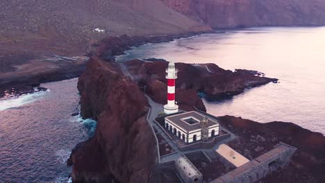 majestic lighthouse of tenerife island on rocky coastline, aerial fly towards view